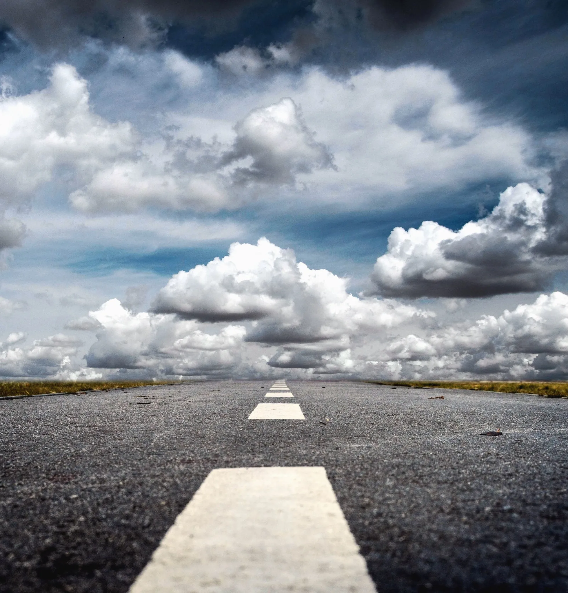 Route vide sous un ciel nuageux laissant apparaître une perspective dégagée